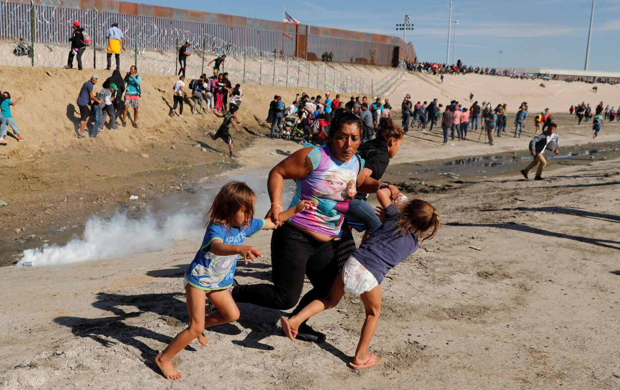 Familia de migrantes cruzando frontera USA